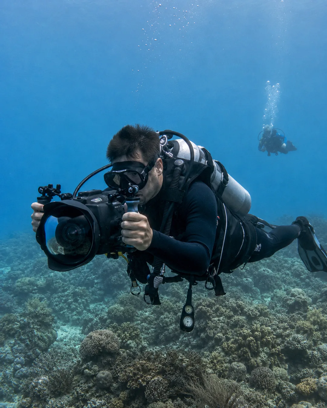 Experienced scuba diver filming over a reef